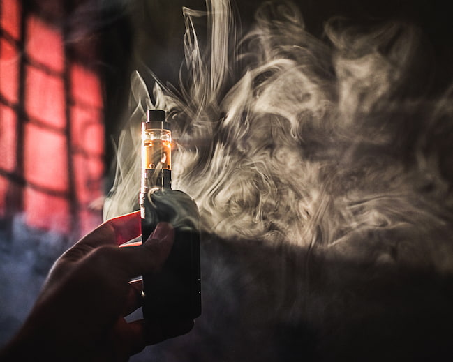 Persona usando cigarrillo electrónico vapeador