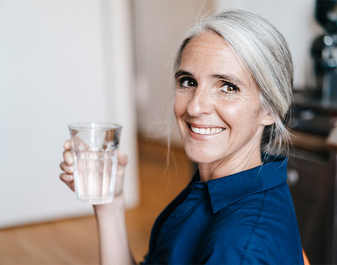 Persona bebiendo agua para mantenerse hidratada