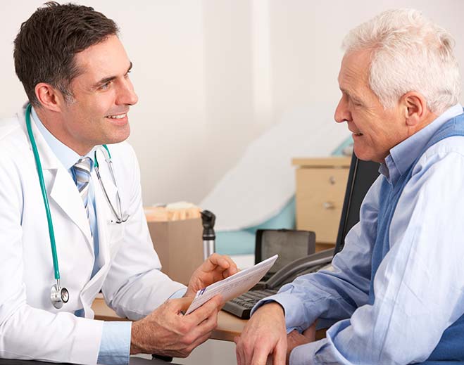 Doctor reviewing document with elderly patient