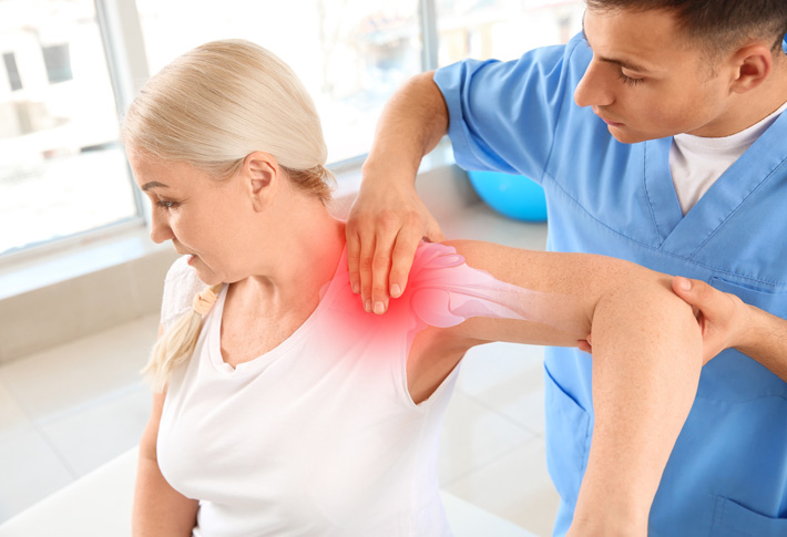Therapist assisting patient with shoulder pain