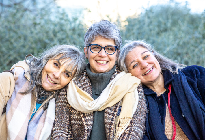 Three people sitting together outdoors