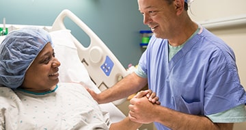 Medical staff comforting patient in bed