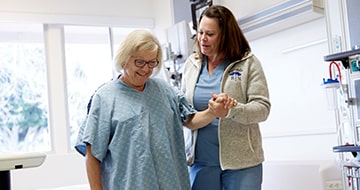 Nurse assisting patient with walking