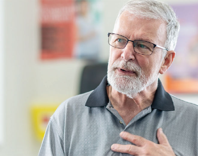 Older adult touching chest, discussing health concern