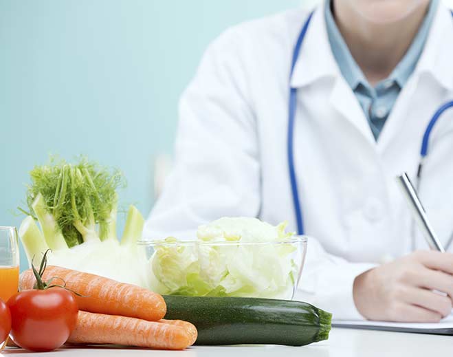Doctor with healthy vegetables on table workstation