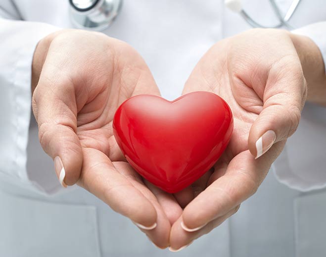 Red heart held in hands symbolizing care