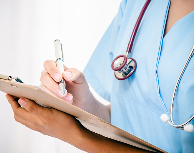Healthcare professional writing notes on clipboard