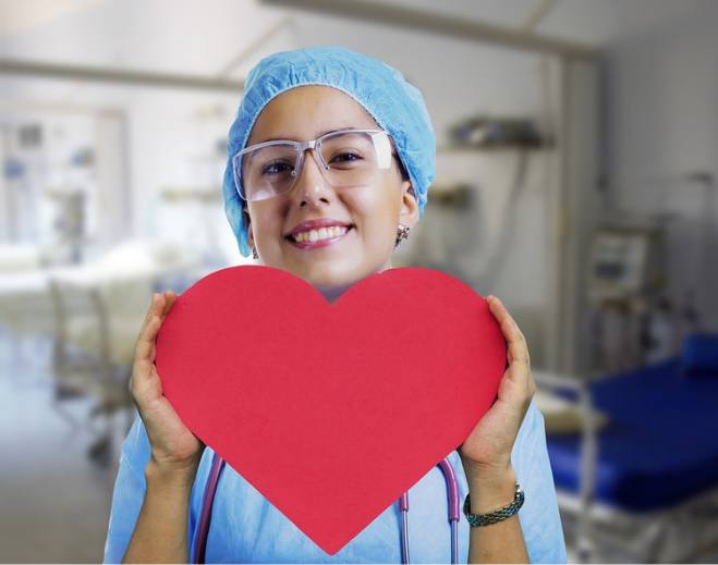 Nurse holding large red heart cutout