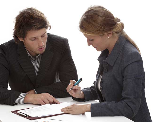 Two people reviewing and signing documents together