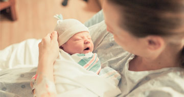 Newborn baby wrapped in hospital blanket