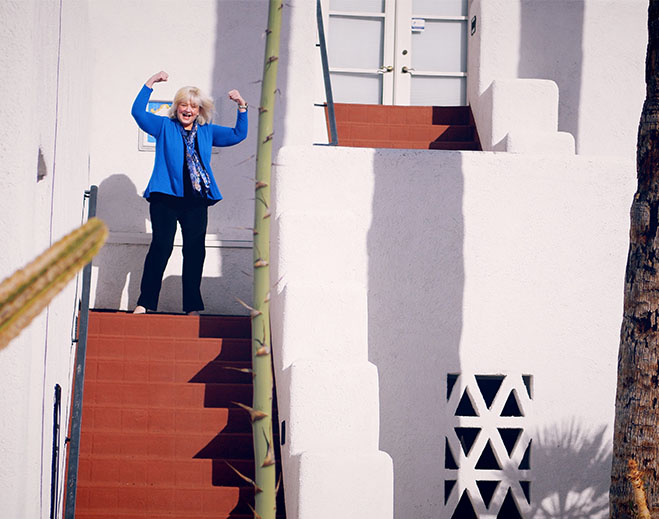 Woman flexing arms on outdoor stairs